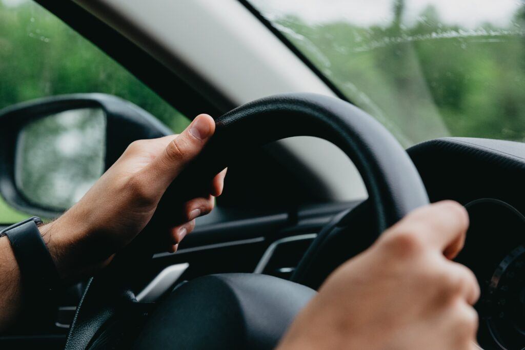 DUI Driving hands on steering wheel black white hands